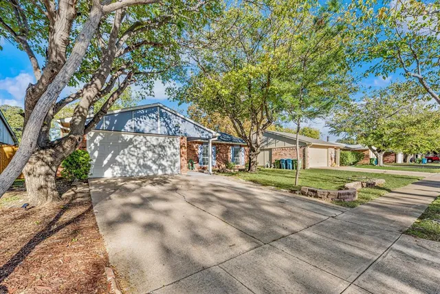 a front view of a house with a yard and trees