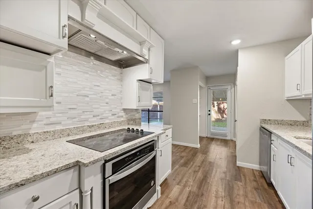 a kitchen with a stove and a wooden floor