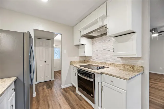 a kitchen with a stove and a wooden floor