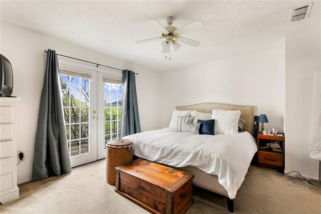 9201 Simmons Road, Unit 117 Austin, TX 78759 - Photo 7 of 11 Room featuring a ceiling fan, light-colored carpeting, white walls, and French doors with exterior views