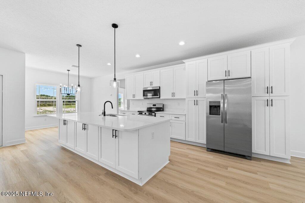 14299 Saddle Ridge Road Macclenny, FL 32063 - Photo 2 of 35 a kitchen with white cabinets and stainless steel appliances