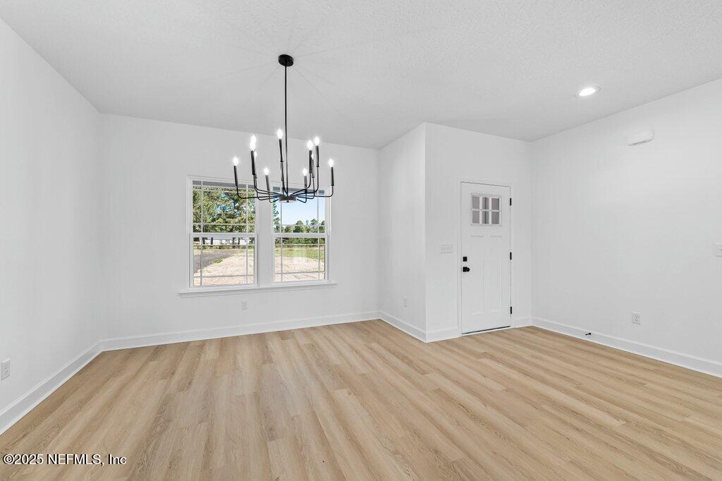 14299 Saddle Ridge Road Macclenny, FL 32063 - Photo 10 of 35 wooden floor in an empty room with a window