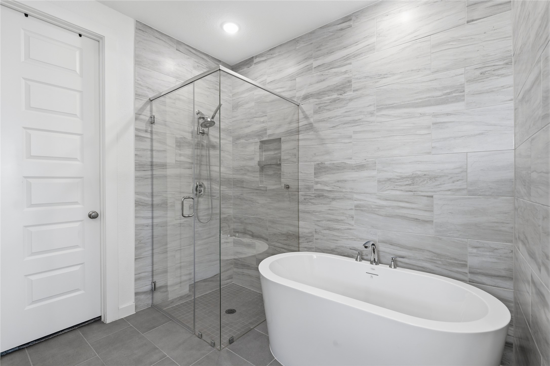 416 Bartlett Street Webster, TX 77598 - Photo 26 of 49 Spa bath with freestanding soaking tub, glass shower, and marble tile walls