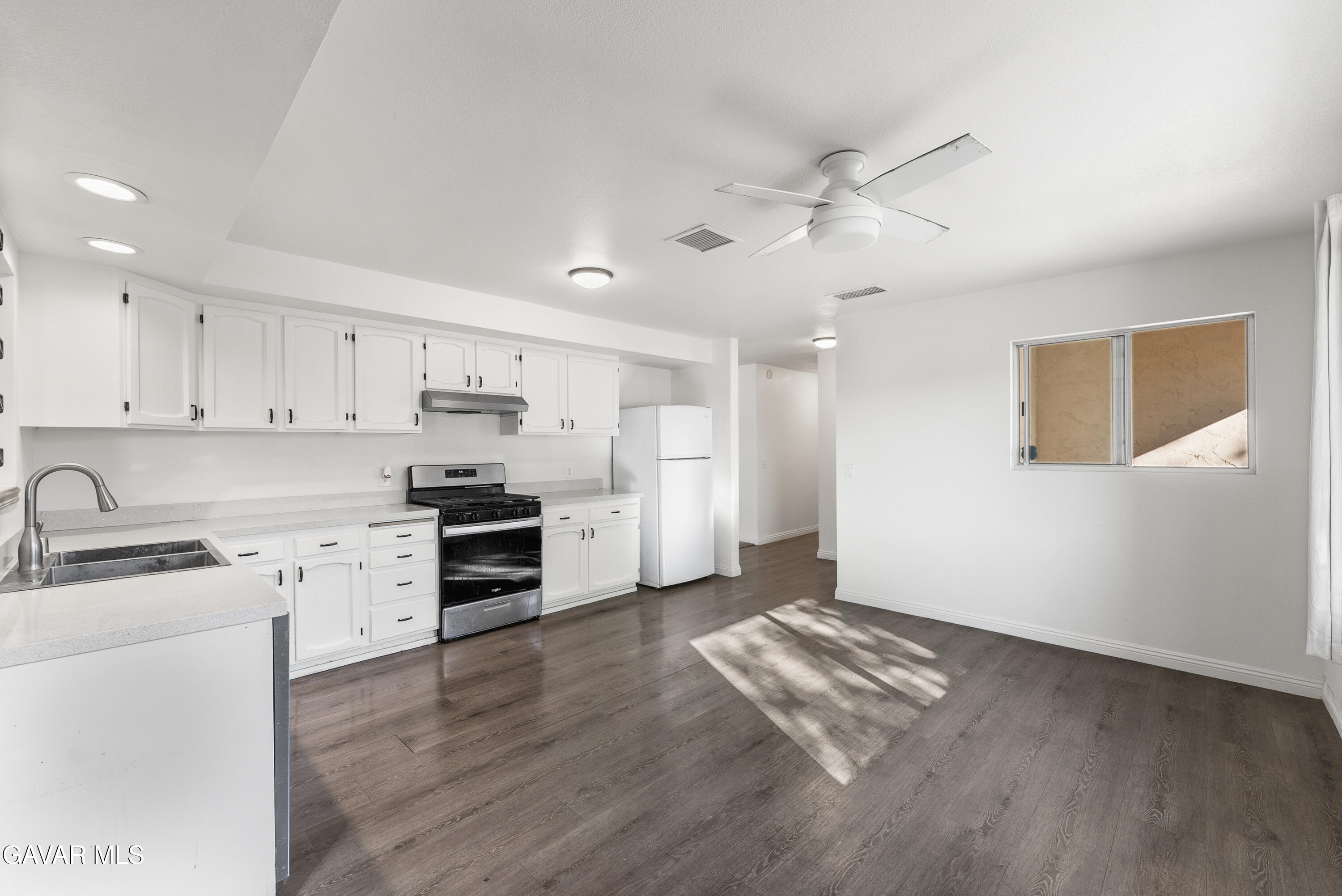 9459 East Ave T 2 Littlerock, CA 93543 - Photo 17 of 54 a kitchen with granite countertop a refrigerator oven a sink dishwasher and a stove with wooden floor
