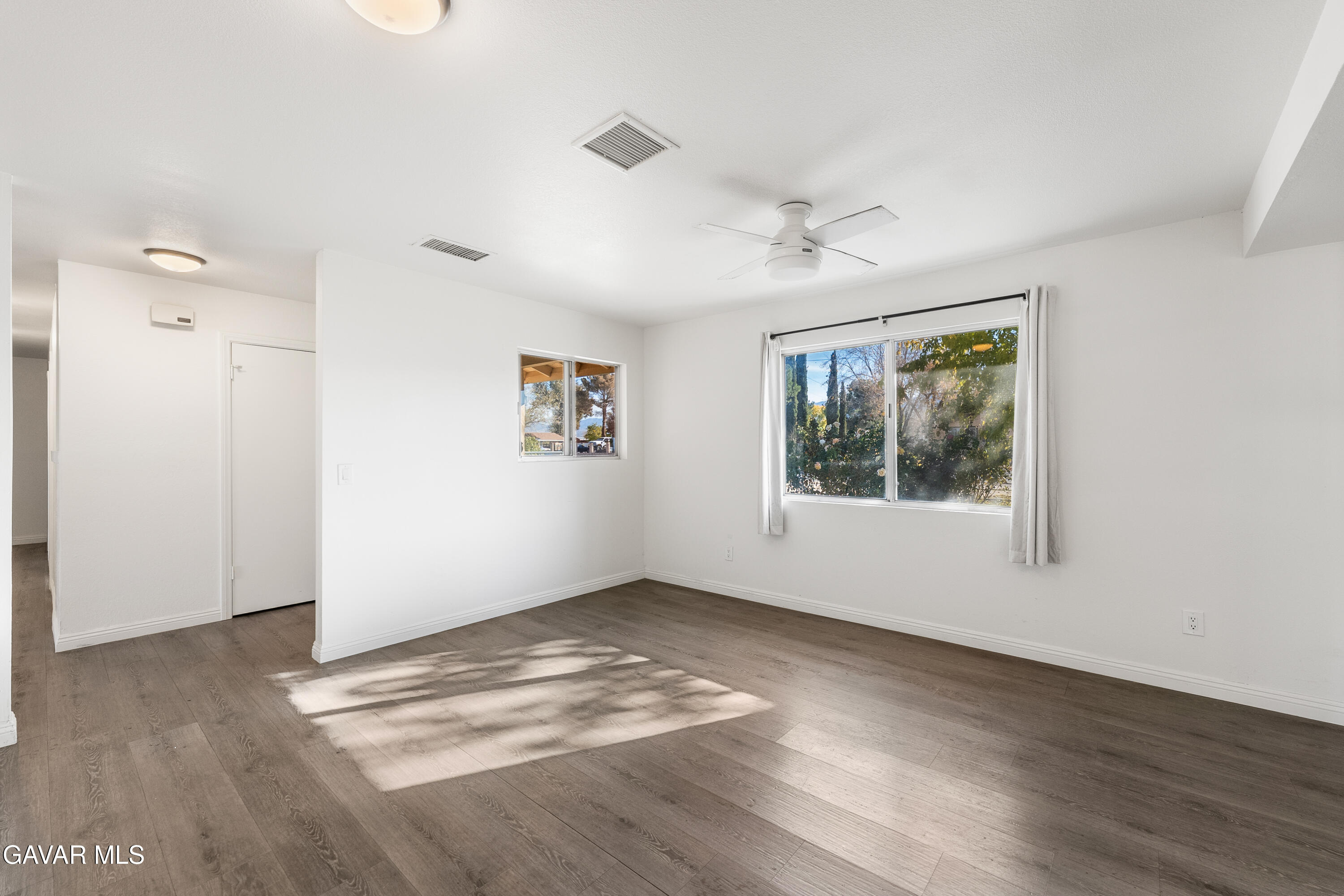 9459 East Ave T 2 Littlerock, CA 93543 - Photo 23 of 54 an empty room with wooden floor and windows