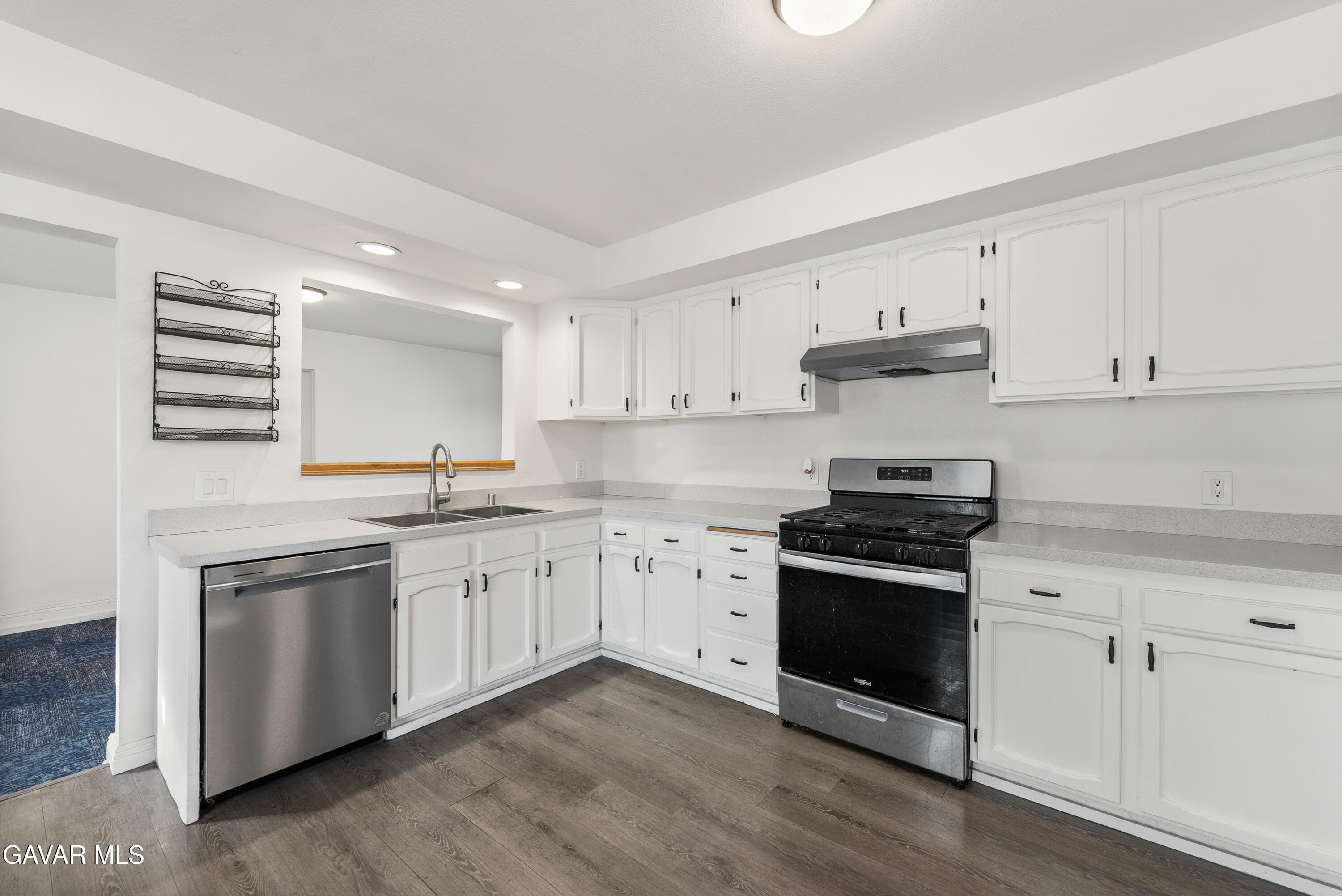 9459 East Ave T 2 Littlerock, CA 93543 - Photo 27 of 54 a kitchen with stainless steel appliances granite countertop a stove and white cabinets