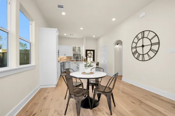 a view of a dining room with furniture a chandelier and wooden floor