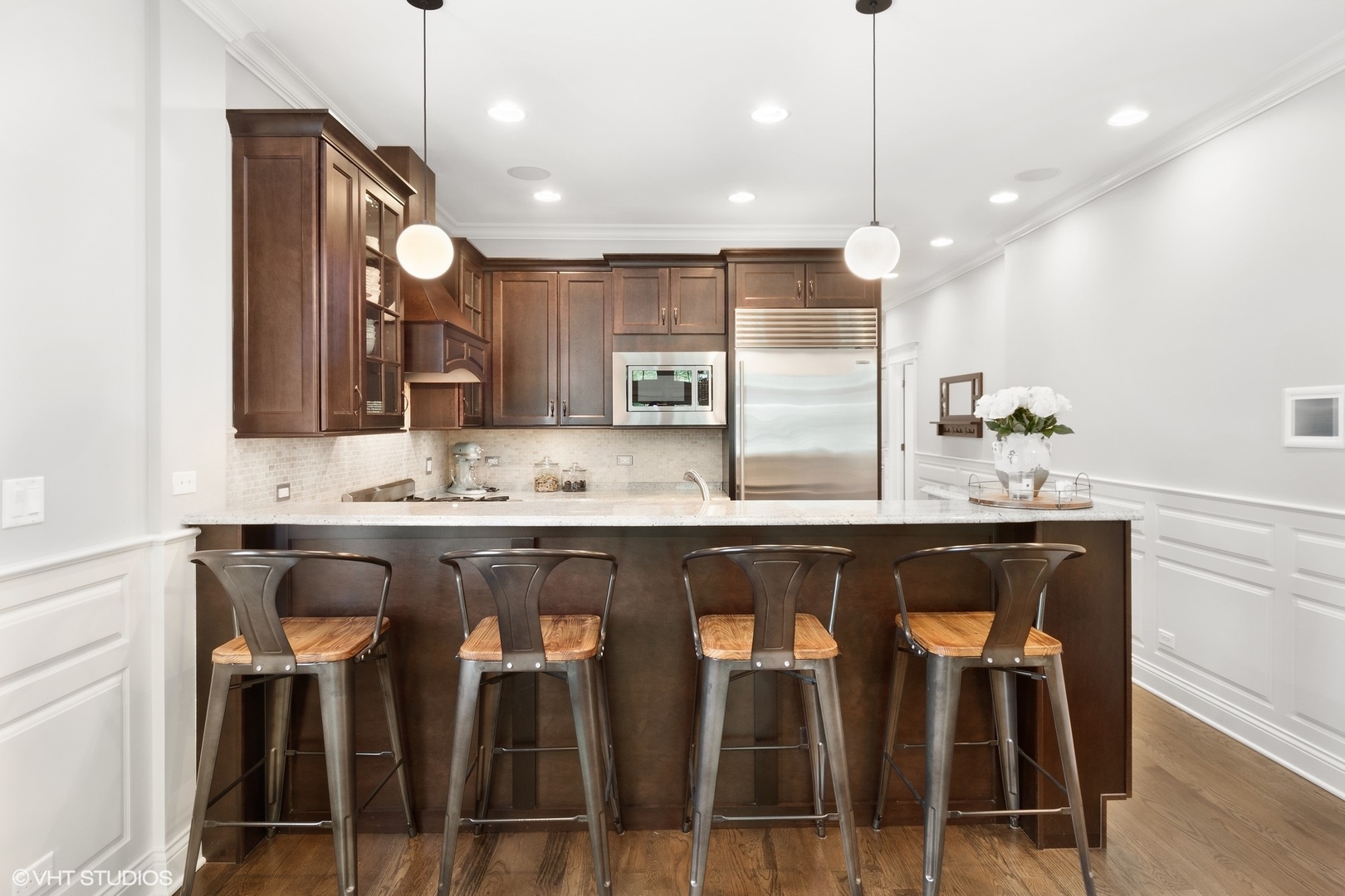 1215 West School Street, Unit 2E Chicago, IL 60657 - Photo 7 of 16 a large kitchen with granite countertop a table chairs sink and cabinets