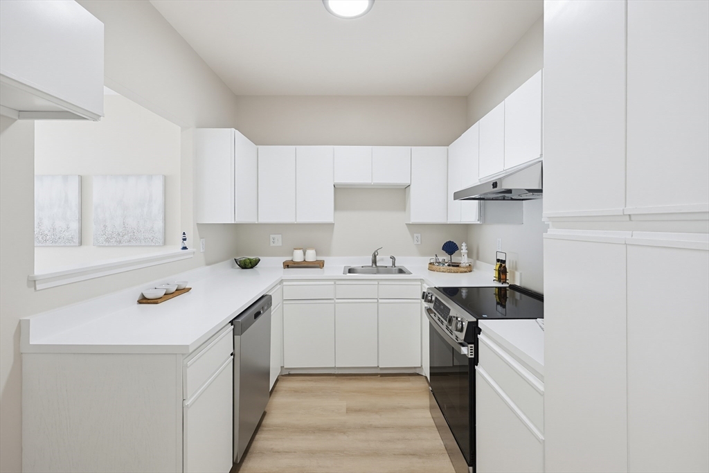 45 Main Street, Unit 35 Wareham, MA 02571 - Photo 7 of 34 a kitchen with a sink stove and cabinets