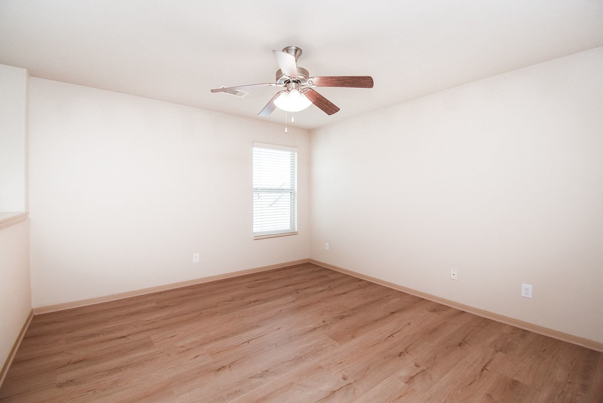 2106 Harmon Crest Court Spring, TX 77373 - Photo 29 of 37 an empty room with wooden floor fan and windows