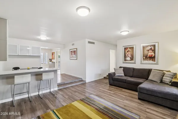 a view of a dining room with furniture a kitchen and chandelier