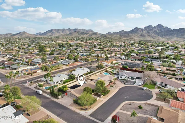 an aerial view of residential houses with outdoor space and trees