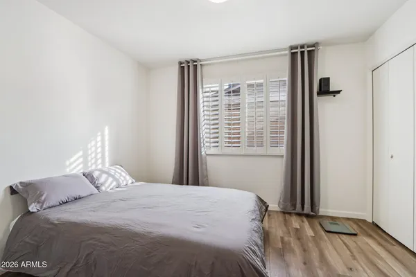 a bedroom with a bed and a painting on the wall