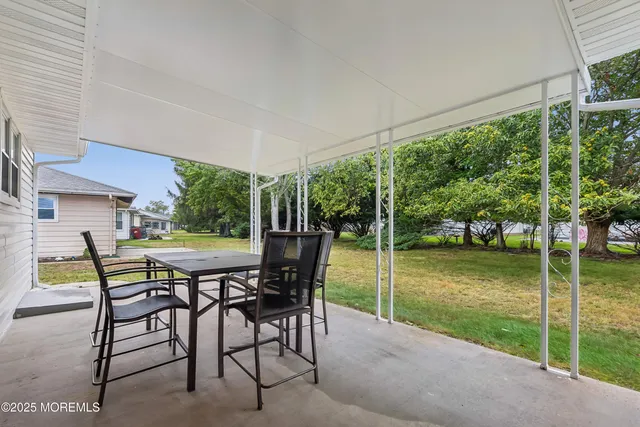 a view of a patio with a table chairs and a backyard