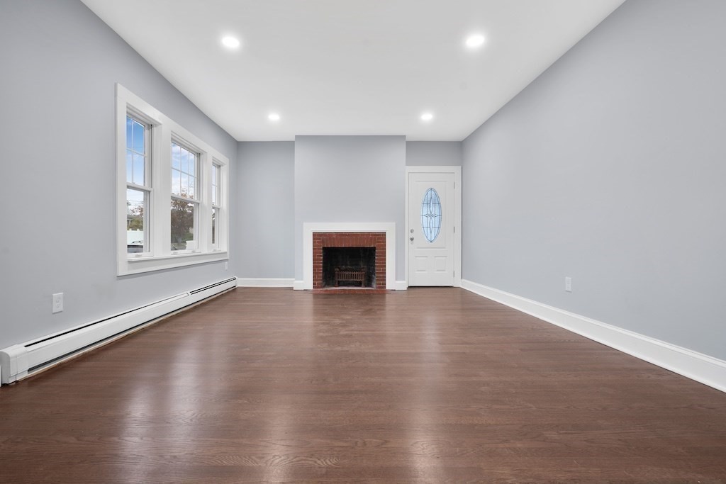 274 Archer Street Fall River, MA 02720 - Photo 11 of 29 an empty room with wooden floor and fireplace