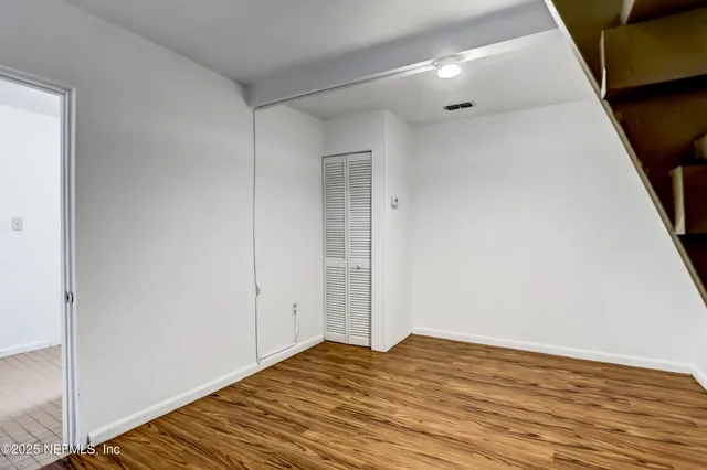 a view of a room with wooden floor and window