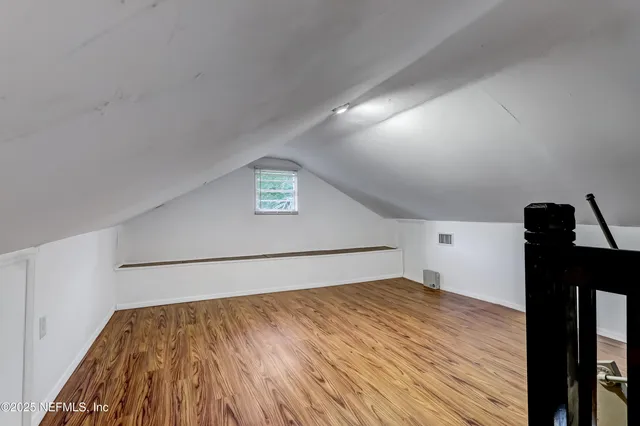 a view of a room with wooden floor and furniture