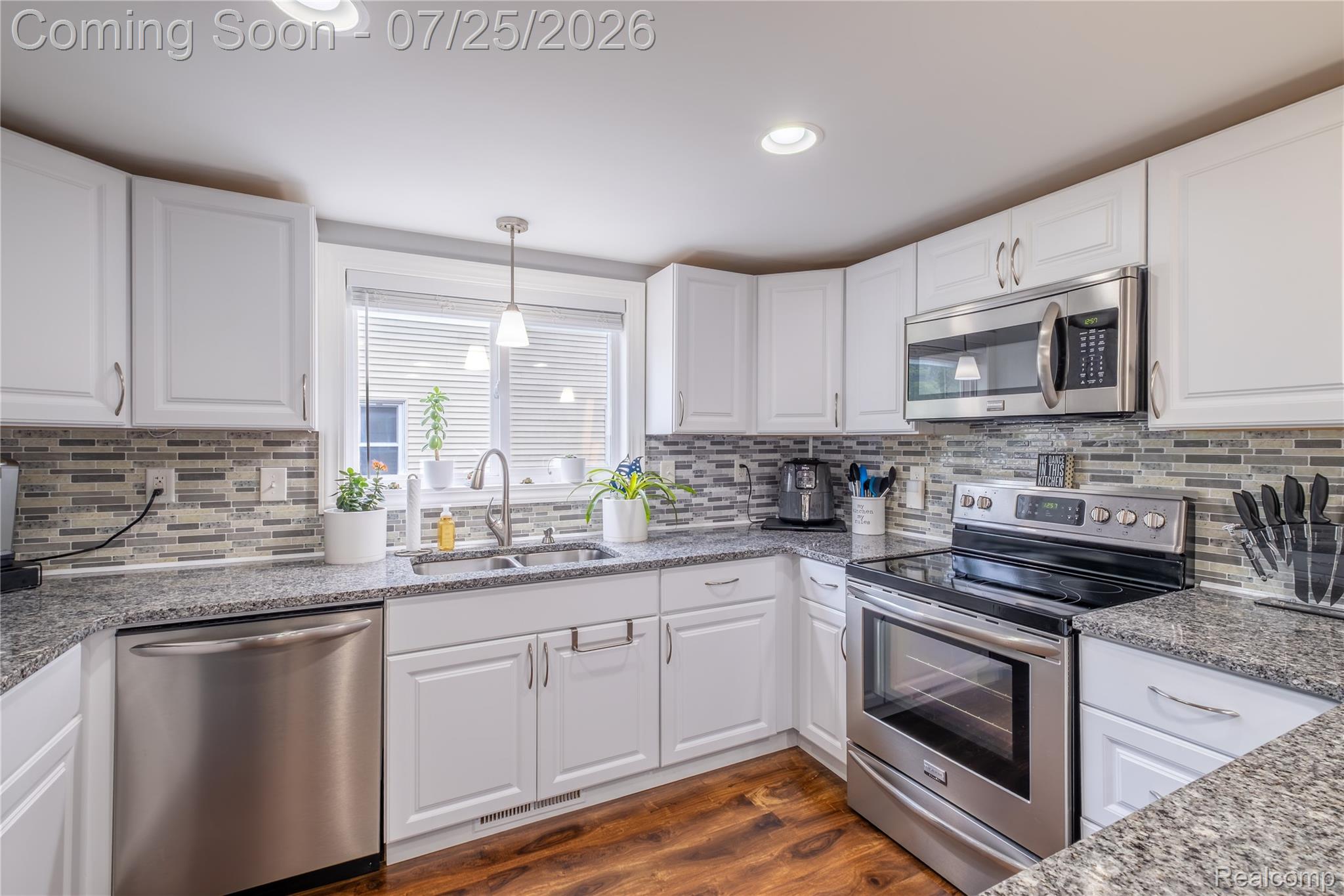 4057 Risedorph Street Burton, MI 48509 - Photo 13 of 23 Kitchen featuring white cabinetry, speckled countertops, stainless steel appliances, and wood-finish flooring