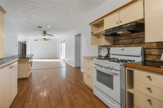 a kitchen with granite countertop a stove and a wooden floors