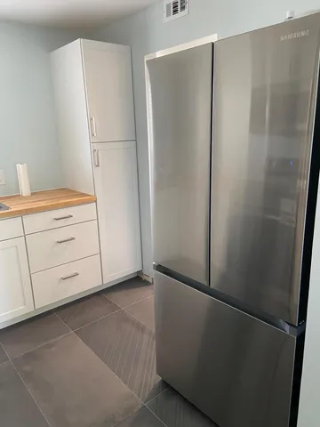 a view of kitchen with stove a microwave and cabinets