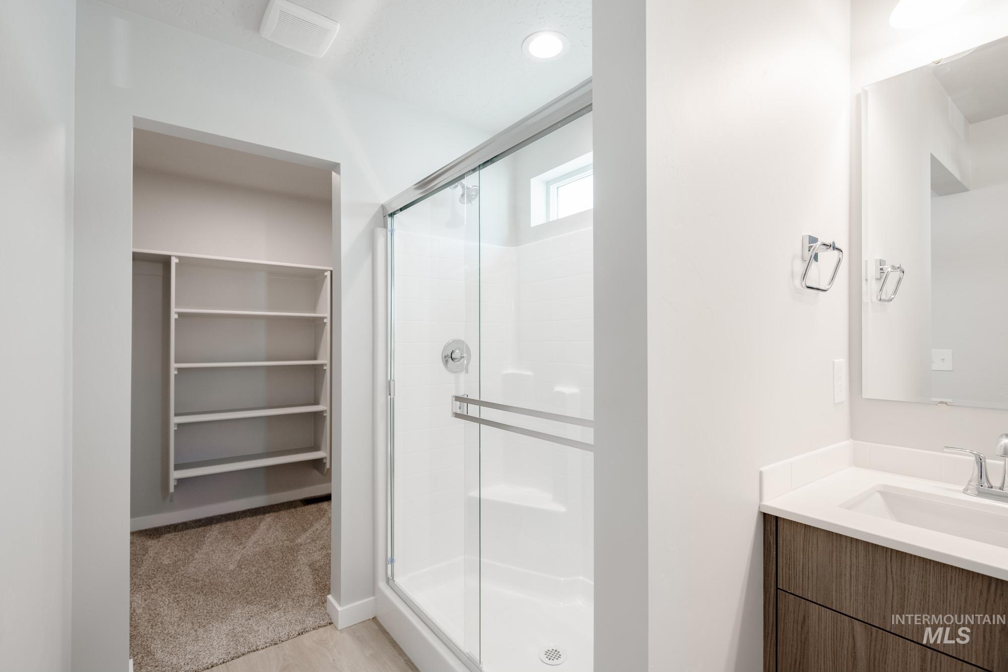 229 Moose Street Horseshoe Bend, ID 83629 - Photo 18 of 26 Bathroom with vanity, a shower stall, a walk in closet, and light carpet