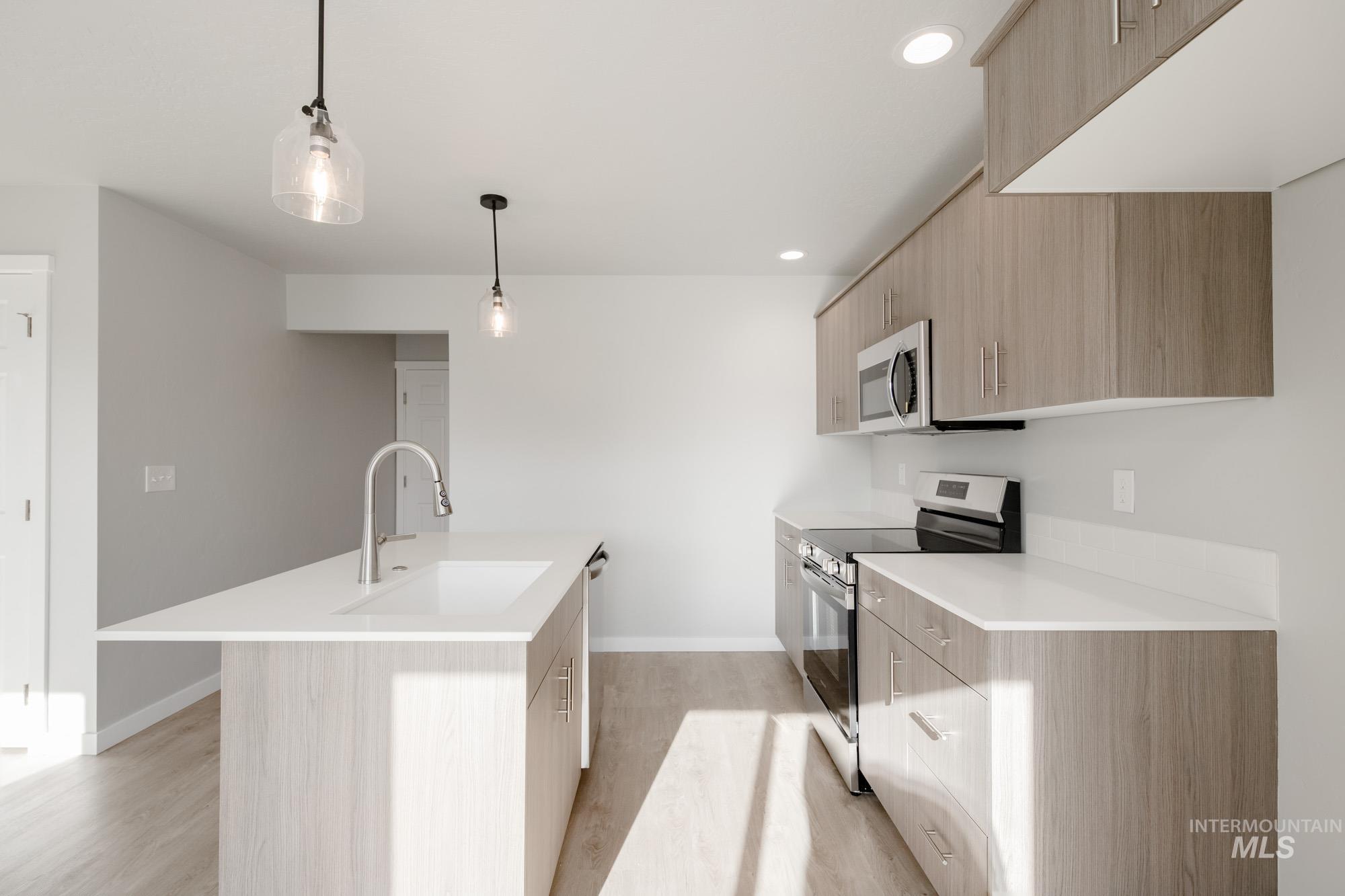 229 Moose Street Horseshoe Bend, ID 83629 - Photo 8 of 26 Kitchen featuring modern cabinets, stainless steel appliances, light brown cabinetry, pendant lighting, and recessed lighting