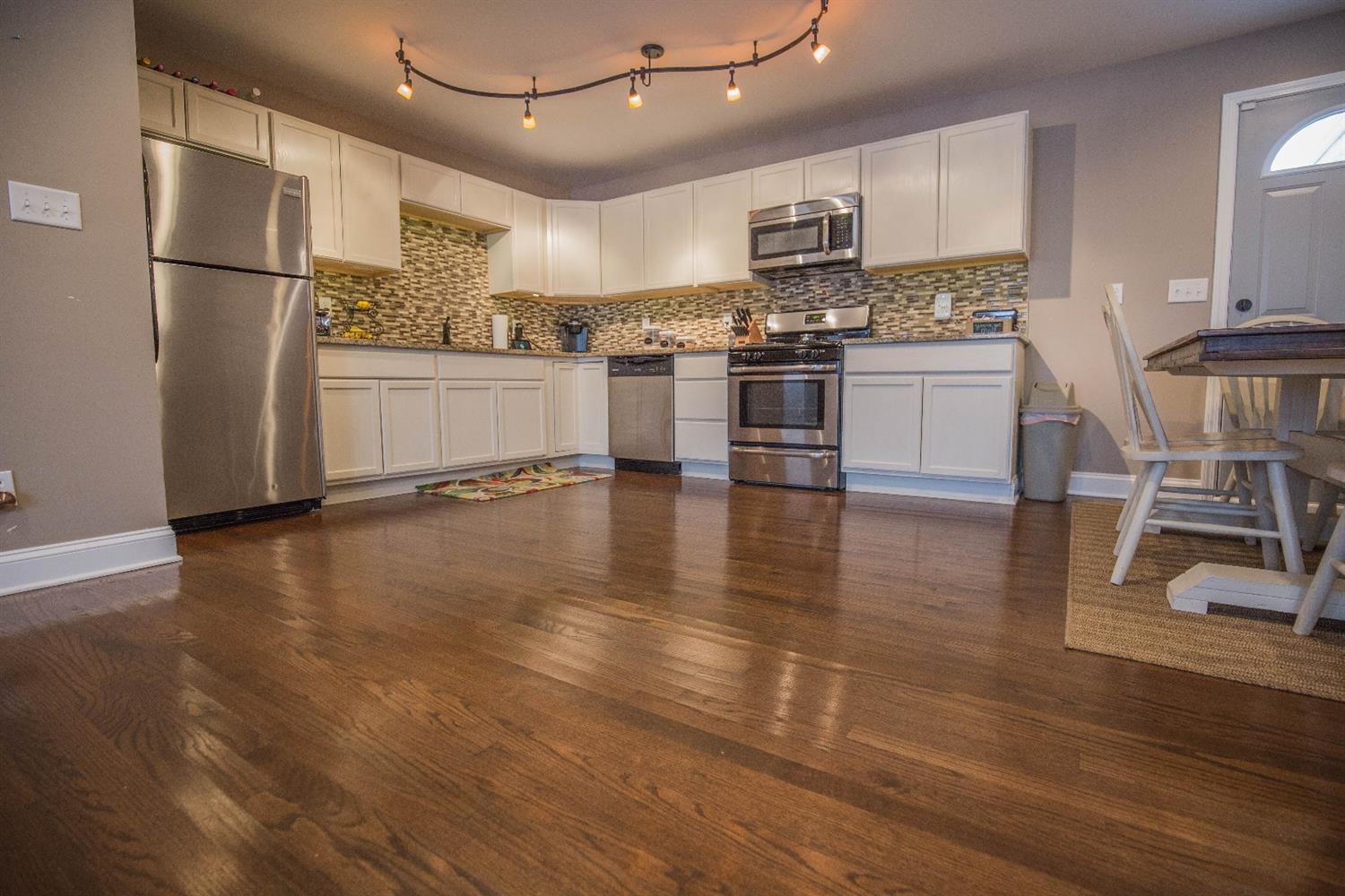712 Fremont Road Valparaiso, IN 46385 - Photo 7 of 11 a kitchen with stainless steel appliances granite countertop a refrigerator a stove top oven a sink and a island with wooden floor