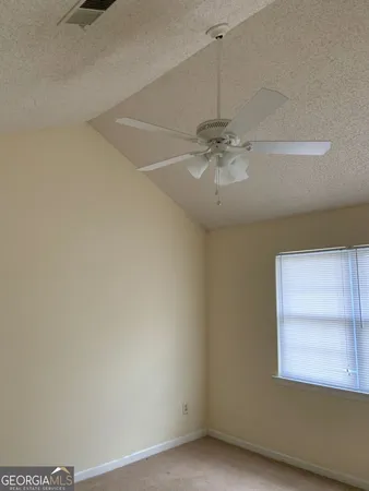 an empty room with a window and a fan