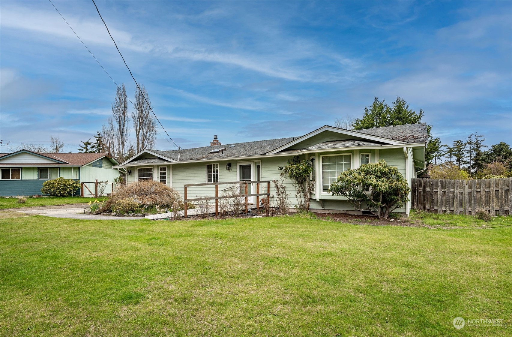 a view of a house with a big yard and large trees