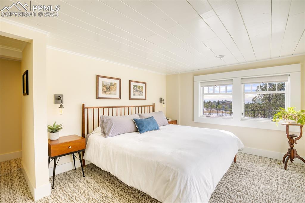 11508 Shaugnessy Road Colorado Springs, CO 80908 - Photo 15 of 49 a spacious bedroom with a bed and a large window