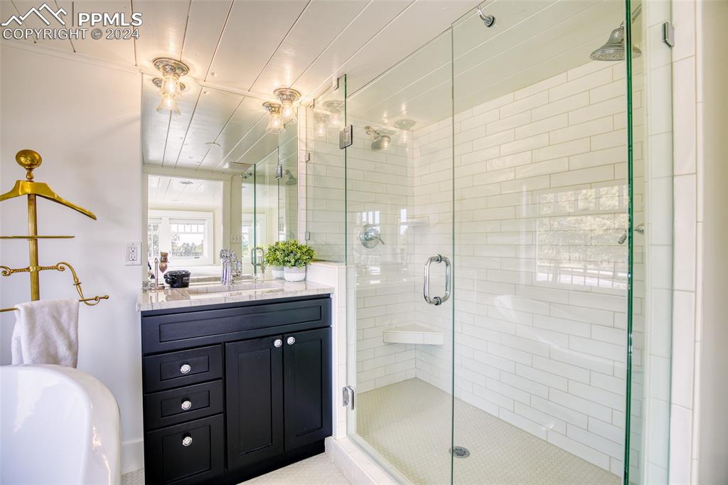11508 Shaugnessy Road Colorado Springs, CO 80908 - Photo 18 of 49 a bathroom with a double vanity sink and mirror