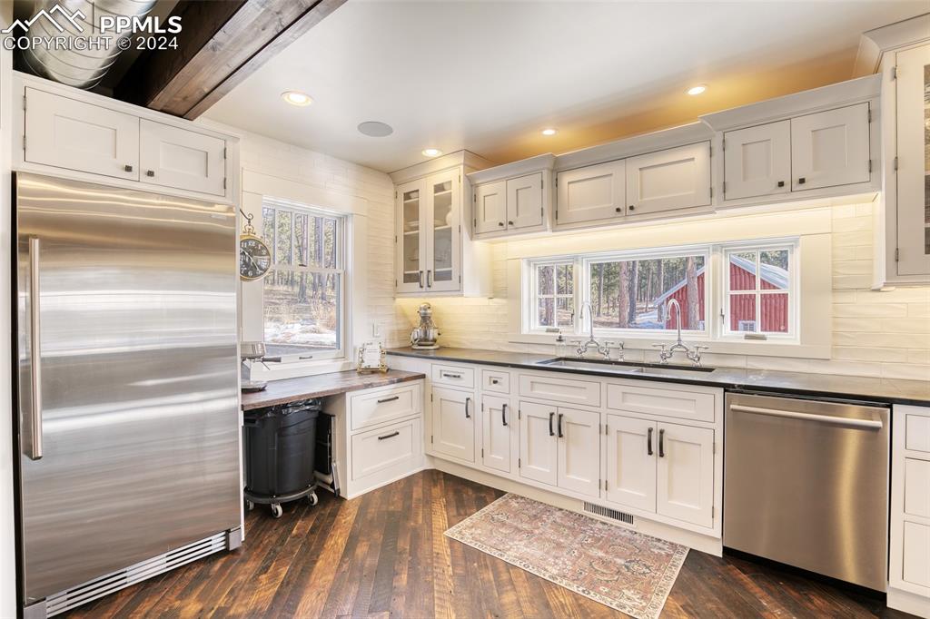 11508 Shaugnessy Road Colorado Springs, CO 80908 - Photo 44 of 49 a kitchen with granite countertop white cabinets and white appliances