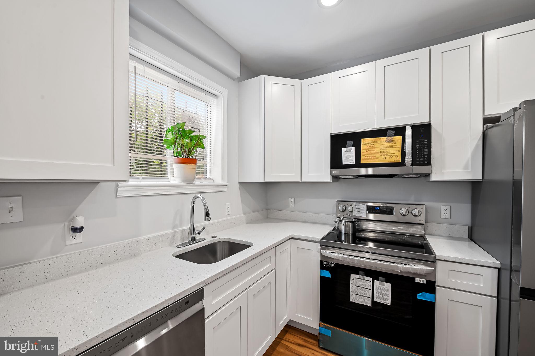 512 North Port Street Baltimore, MD 21205 - Photo 7 of 23 a kitchen with stainless steel appliances a sink a stove a microwave and cabinets