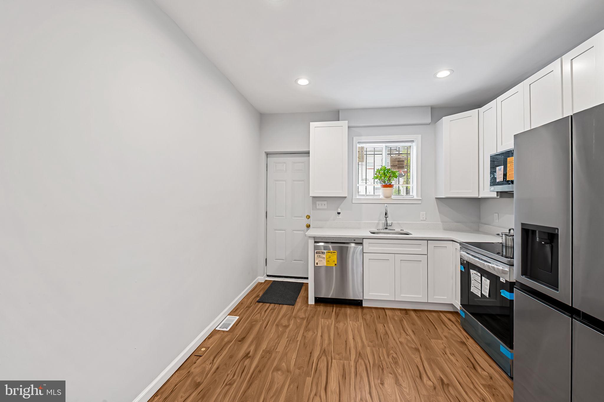 512 North Port Street Baltimore, MD 21205 - Photo 8 of 23 a kitchen with wooden floors and white appliances