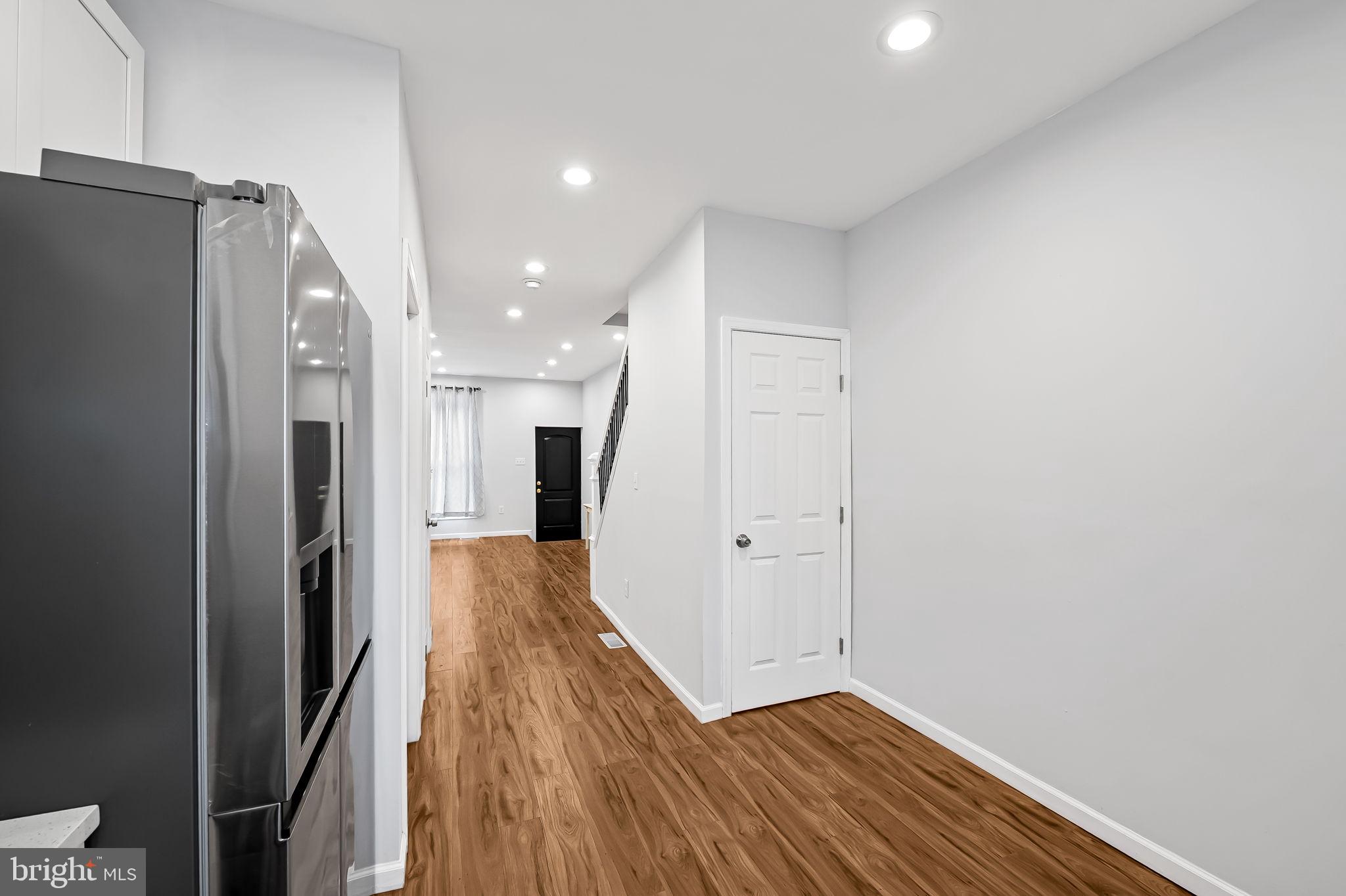 512 North Port Street Baltimore, MD 21205 - Photo 10 of 23 a view of a hallway with wooden floor and a refrigerator