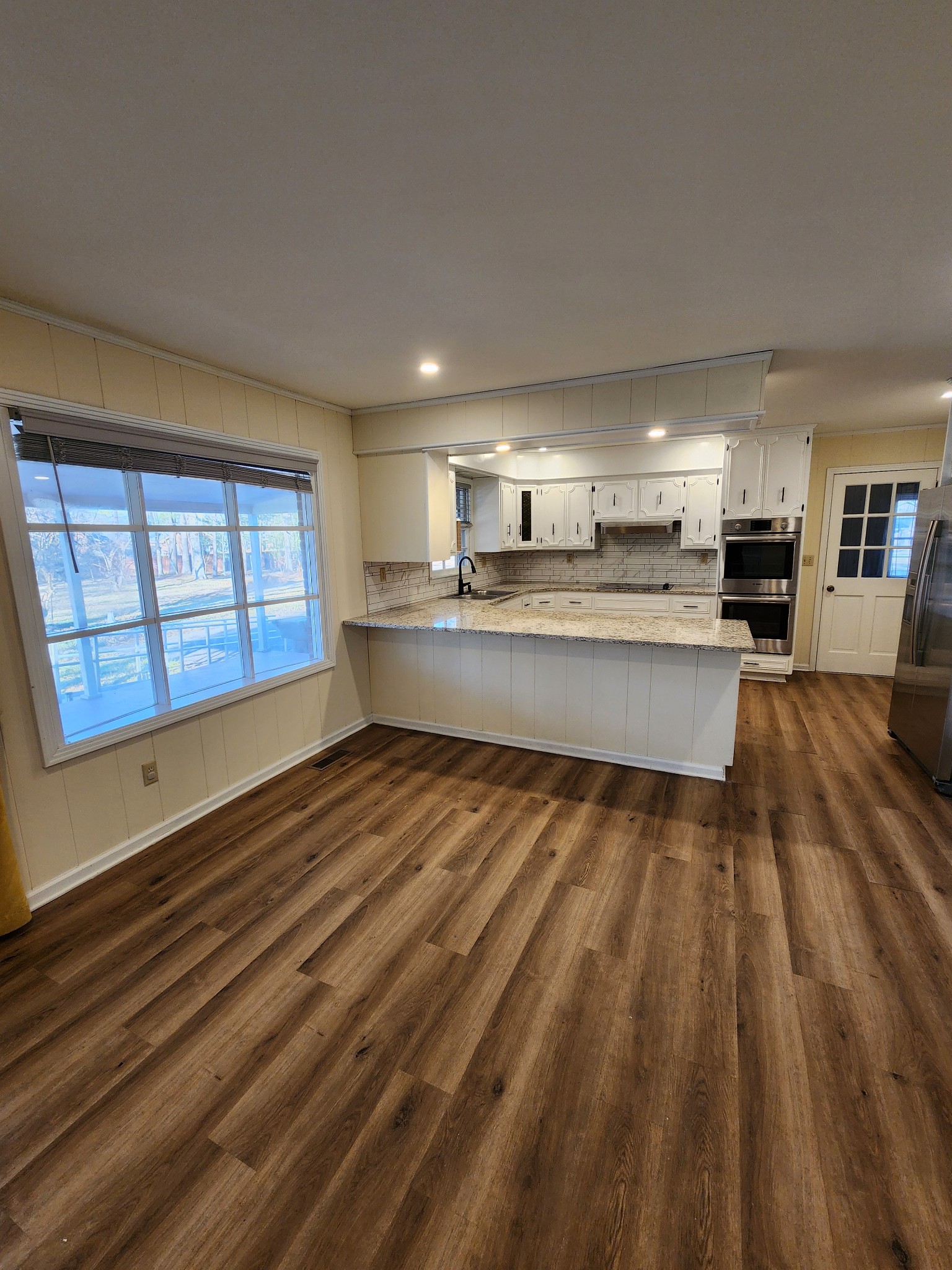 303 12 Oaks Road Tullahoma, TN 37388 - Photo 23 of 39 a large kitchen with kitchen island a stove a sink dishwasher and wooden cabinets