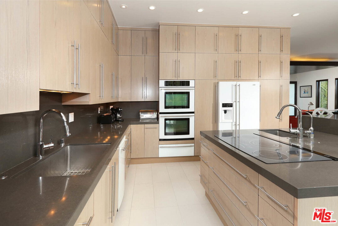 8532 Ridpath Drive Los Angeles, CA 90046 - Photo 10 of 52 a kitchen with kitchen island granite countertop a sink stainless steel appliances and cabinets