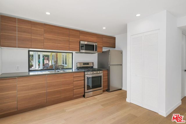 a kitchen with stainless steel appliances granite countertop a stove and a refrigerator