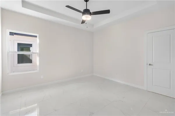 an empty room with a window and a fan