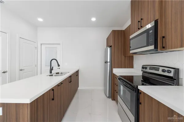 a kitchen with stainless steel appliances a sink stove and cabinets