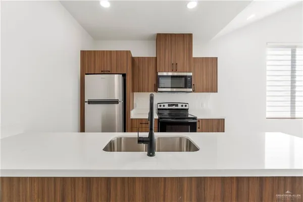 a kitchen with a refrigerator and a stove top oven