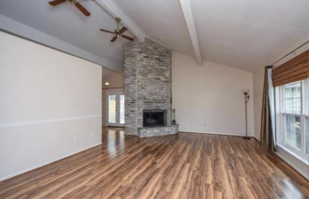 5906 Flower Gate Drive Spring, TX 77373 - Photo 2 of 7 a view of a livingroom with wooden floor a fireplace and window