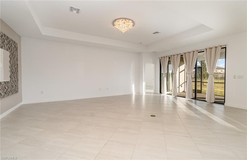 11127 Canopy Loop Fort Myers, FL 33913 - Photo 6 of 29 Empty room featuring a tray ceiling, light tile patterned flooring, and suspended lighting