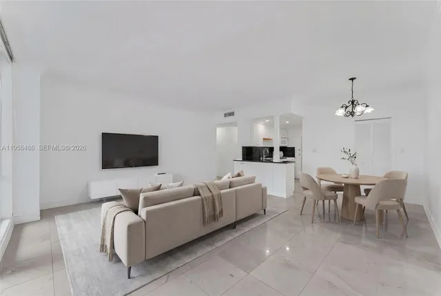 a living room with furniture kitchen view and a flat screen tv