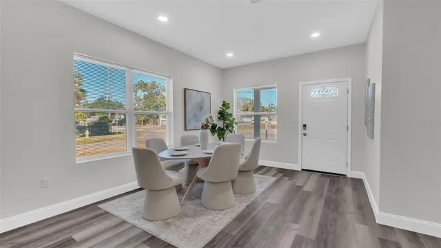 a dining room with wooden floor and a potted plant