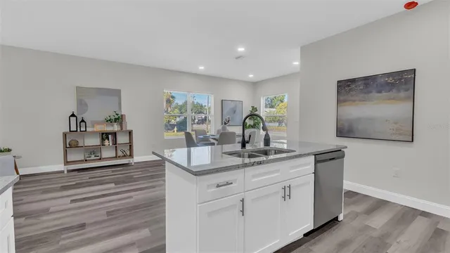 a bathroom with a granite countertop sink mirror and a bathtub