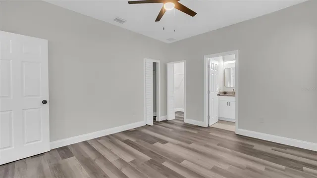 a view of empty room with wooden floor and window