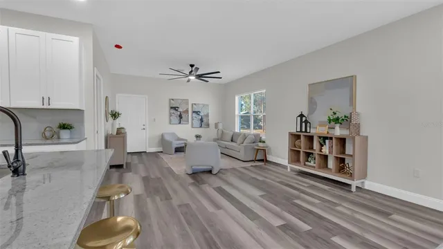 a living room with furniture and a wooden floor