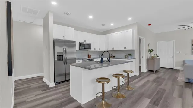 a kitchen with a refrigerator a sink and cabinets