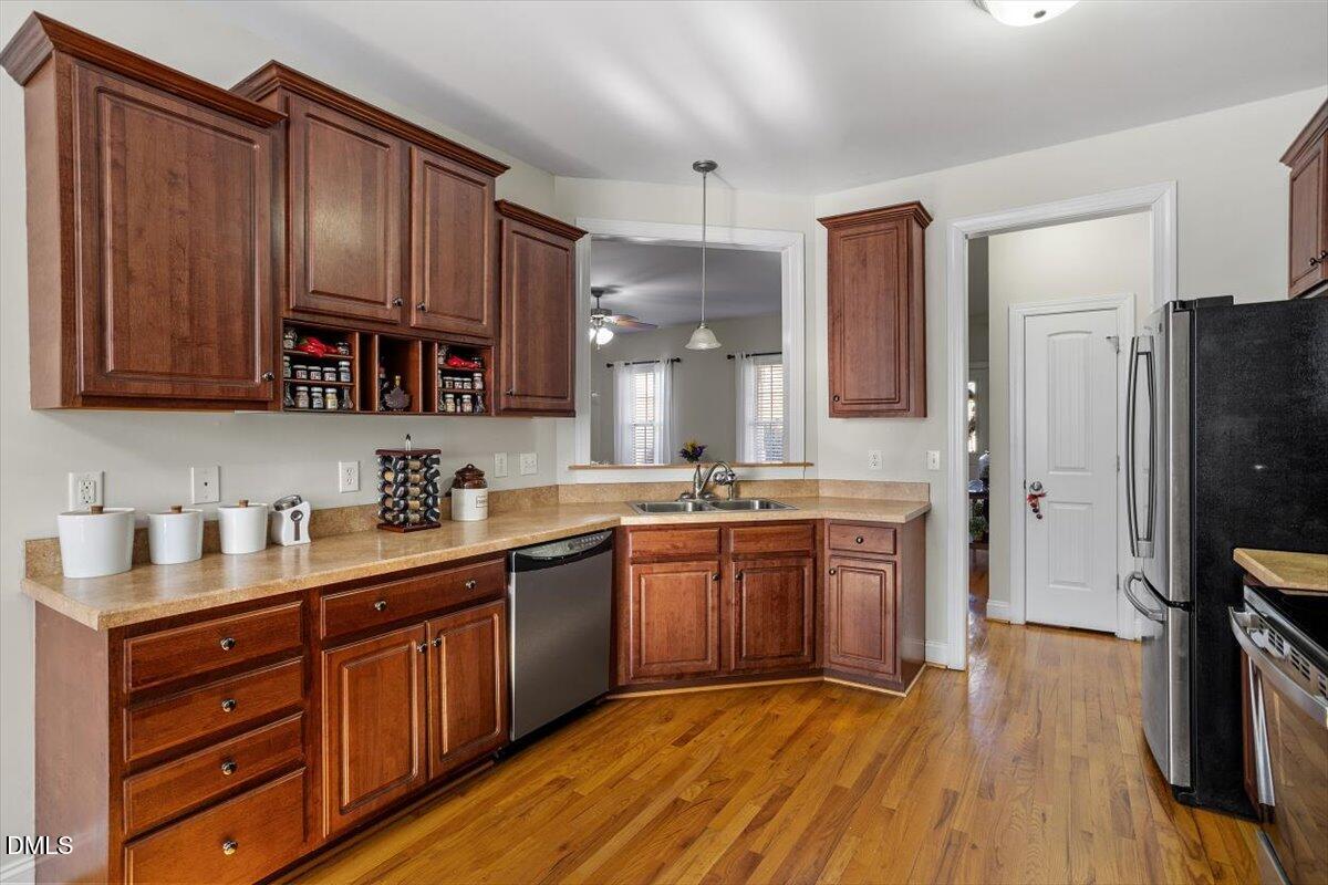 541 Spruce Meadows Lane Willow Spring, NC 27592 - Photo 14 of 40 a kitchen with stainless steel appliances granite countertop wooden cabinets a stove a sink and dishwasher with wooden floor
